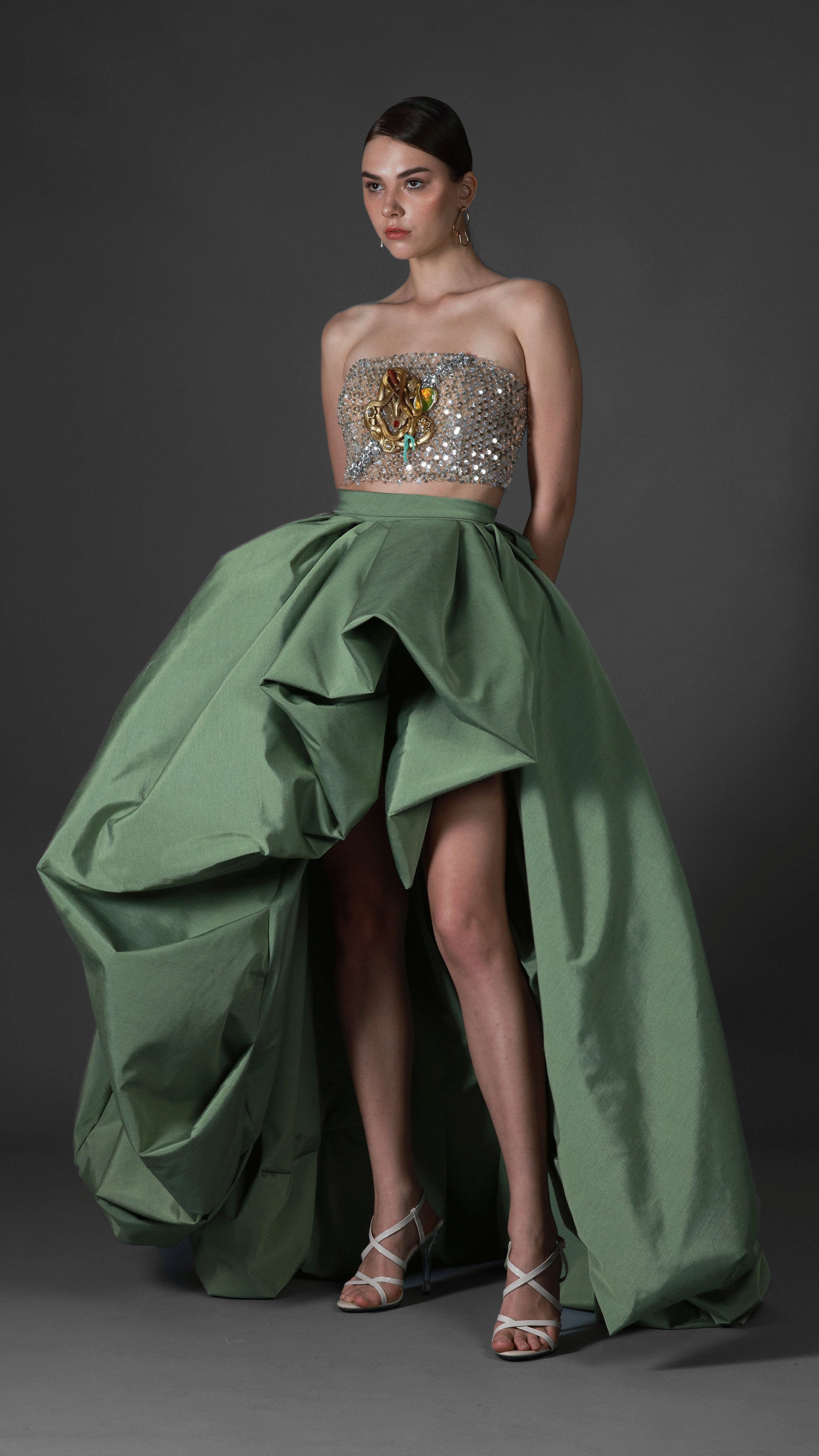 Gold-beaded evening gown with sculptural emerald skirt and cape by Barrage Paris